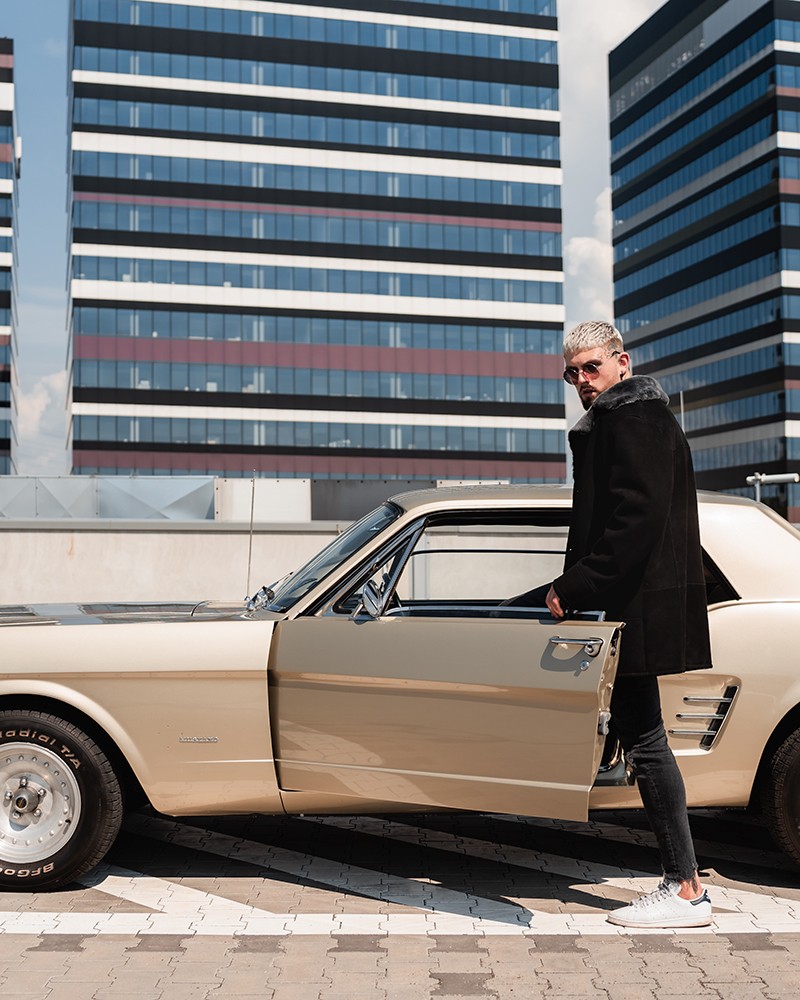 Czarny kożuch męski z szerokim kołnierzem, idealny na zimowe dni, stylowy i elegancki w miejskim otoczeniu