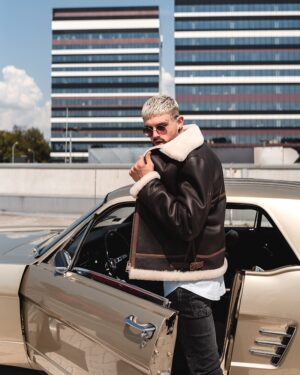 Kożuch męski w kolorze czarnym z białym futrzanym kołnierzem i paskiem, idealny na zimowe dni