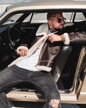 Męski kożuch w brązowym kolorze z białym futrem, zapinany na suwak, z kieszeniami i modnym krojem