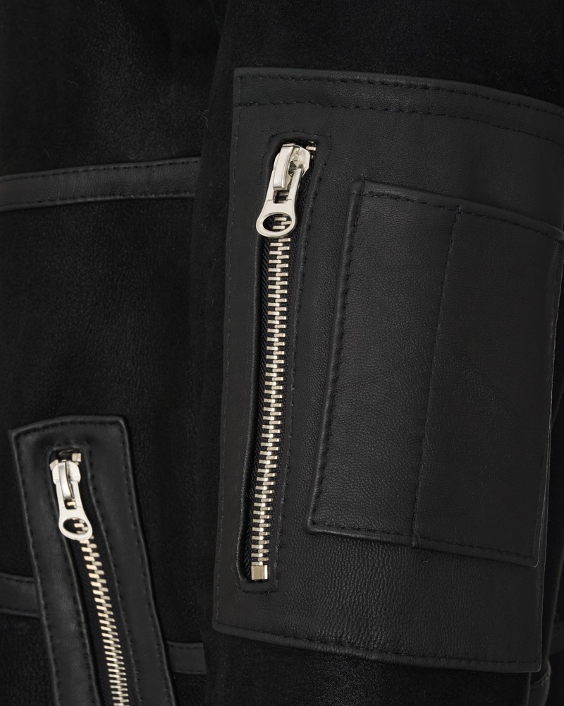 czarny kożuch męski z ozdobnymi zamkami i kieszeniami na rękawach