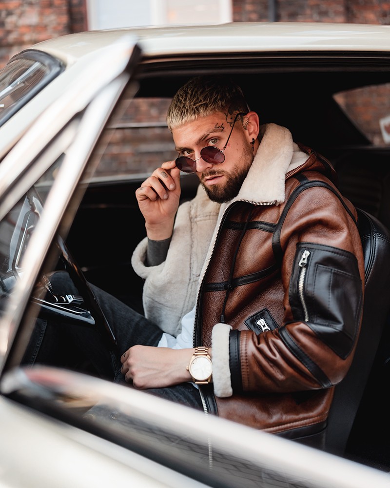 Męski kożuch w brązowym kolorze z białym futrem, z zamkami i stylowym krojem, idealny na zimowe dni