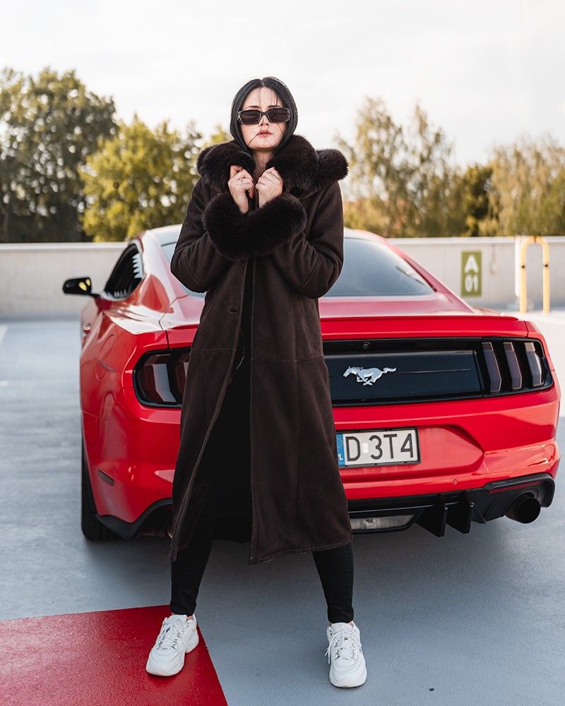 Kożuch damski w ciemnym odcieniu z futrzanym kołnierzem, zapinany na zamek, idealny na zimowe dni