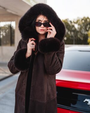 Kożuch damski w ciemnym odcieniu z dużym futrzanym kapturem i mankietami, elegancki krój i wygodne zapięcie