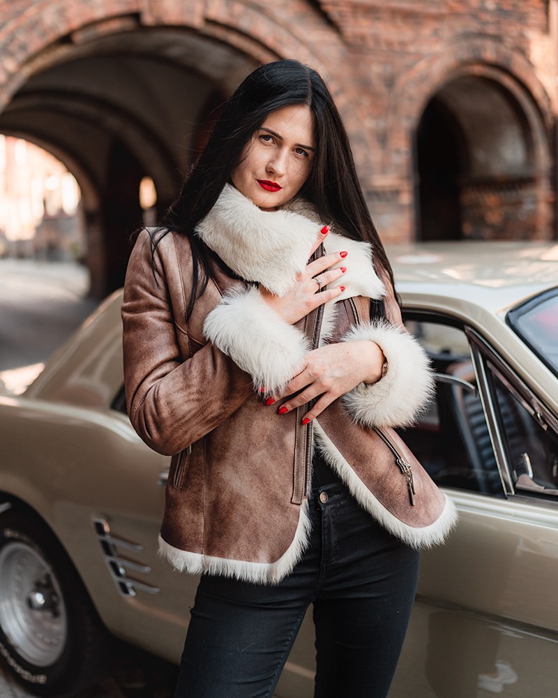 Kożuch damski w kolorze brązowym z białym futrem, zapinany na zamek, z szerokim kołnierzem i rękawami