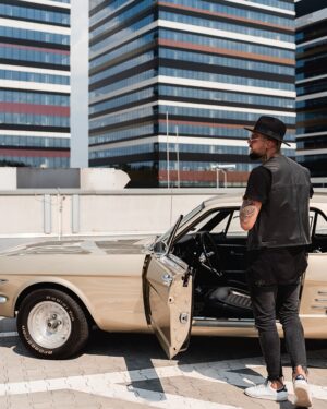 Kamizelka skórzana męska w kolorze czarnym z widocznymi przeszyciami, noszona na tle klasycznego samochodu