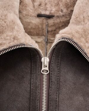 kożuch męski w ciemnym kolorze z miękkim futrem, z wygodnym zamkiem błyskawicznym oraz wysokim kołnierzem