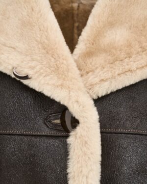 Kożuch damski w ciemnym kolorze z beżowym kołnierzem i dużymi guzikami, idealny na zimowe dni