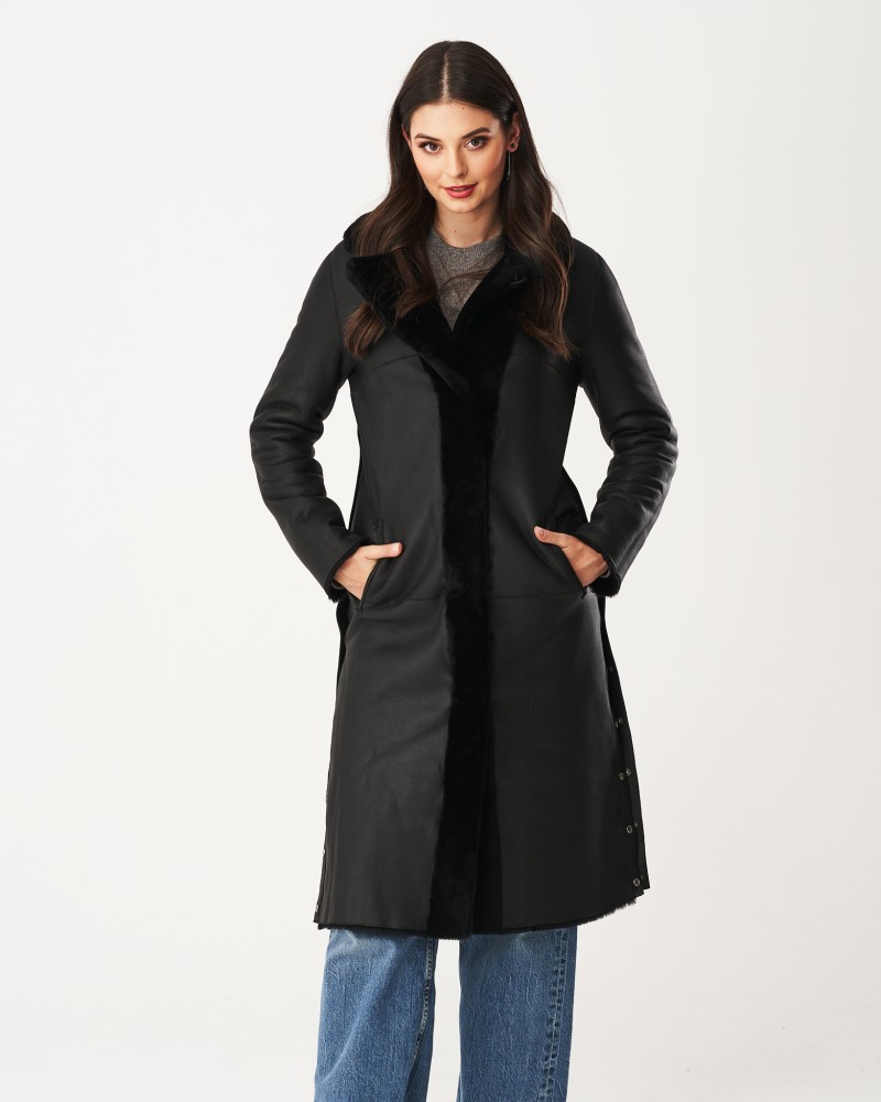 Czarny kożuch damski z długim krojem, z futrzanym kołnierzem i kieszeniami po bokach