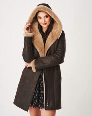 Kożuch damski w ciemnym kolorze z kapturem i futrzanym wykończeniem, zapinany na zamek i z kieszeniami.