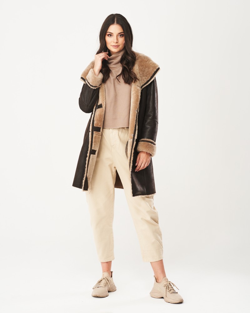 Kożuch damski w kolorze czarnym z szerokim kołnierzem i jasnym futrem, zapinany na guziki