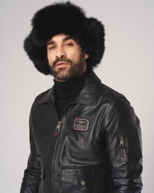 Kurtka lotnicza w kolorze czarnym z kieszeniami i logo, noszona z futrzaną czapką na głowie