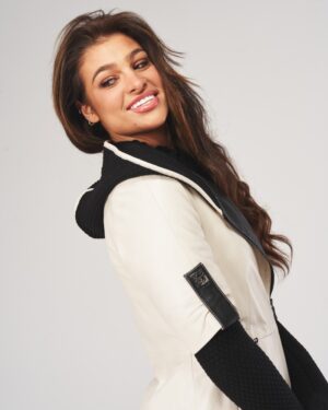 Kurtka skórzana damska w jasnym kolorze z czarnym kapturem i ozdobnymi detalami na rękawach