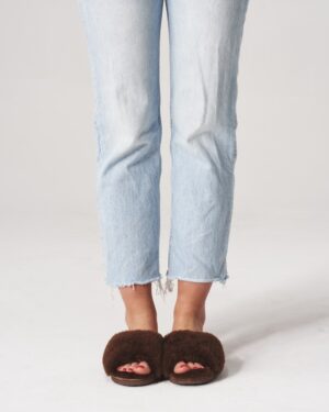 brązowe kapcie futrzane na gołych stopach, idealne na zimowe wieczory w domu