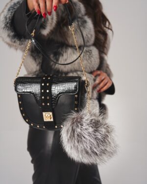 Czarna torebka skórzana z ozdobnymi ćwiekami i futrzanym pomponem, idealna do zimowych stylizacji